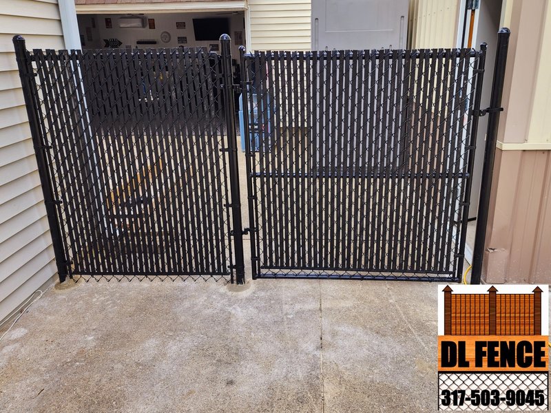 Durable black chain link fence upgraded with privacy slats for side yard privacy. Installed by DL Fence – 800x600